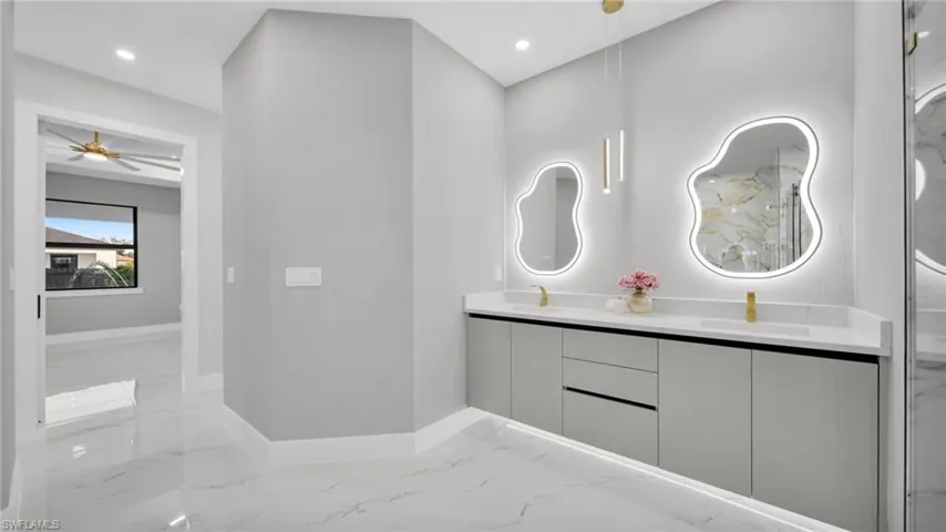 Full bathroom featuring a ceiling fan, double vanity, light marble finish floors, and recessed lighting