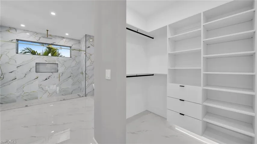 Walk in closet with light marble finish flooring