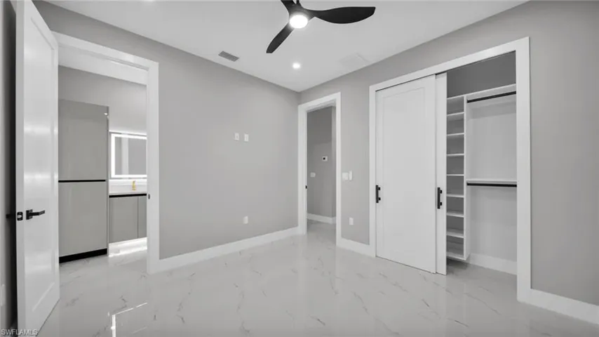 Unfurnished bedroom with light marble finish floors, a closet, recessed lighting, and ceiling fan