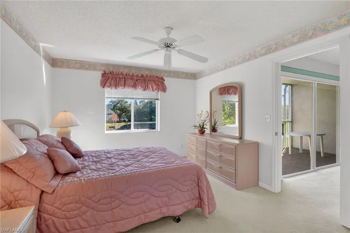 Carpeted bedroom with a textured ceiling and a ceiling fan