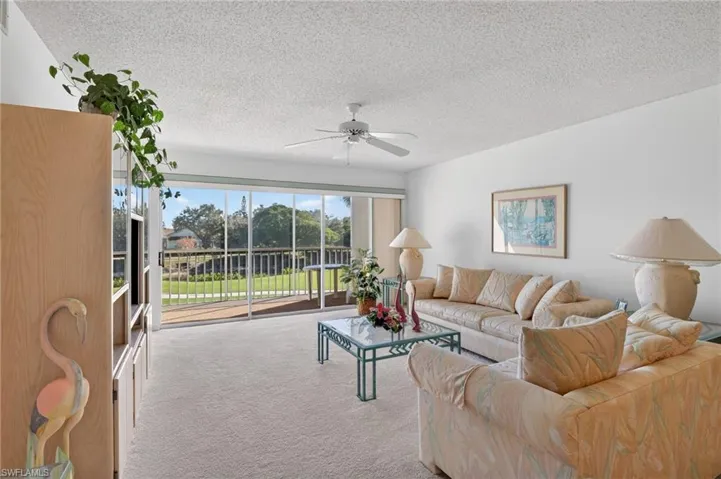 Living area with carpet, a textured ceiling, and ceiling fan