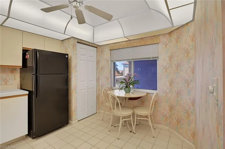 Dining room featuring light tile patterned floors, wallpapered walls, and a ceiling fan