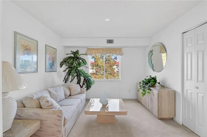 Living area featuring carpet flooring and baseboards