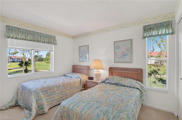 Carpeted bedroom with baseboards and a textured ceiling