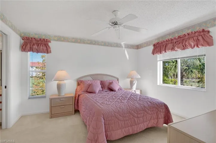 Bedroom featuring carpet, a ceiling fan, and a textured ceiling
