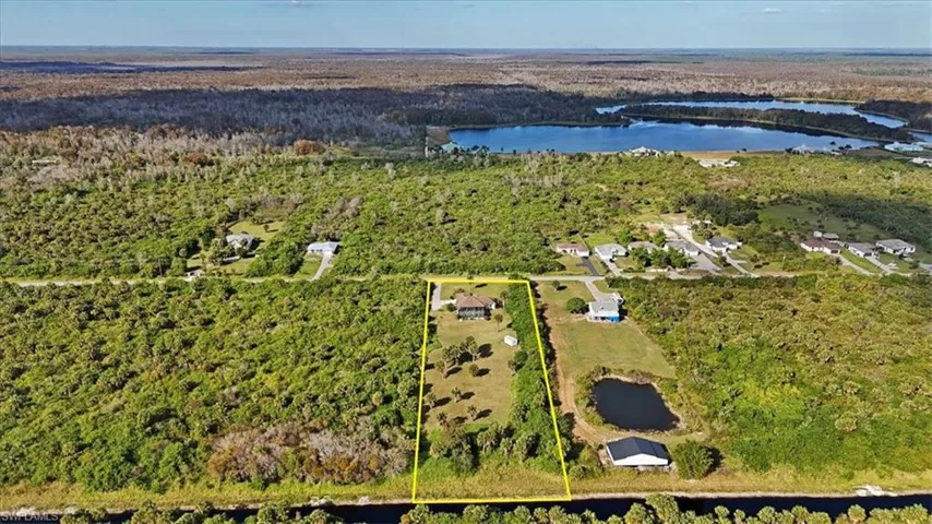 Aerial overview of property's location featuring a large body of water and property parcel outlined