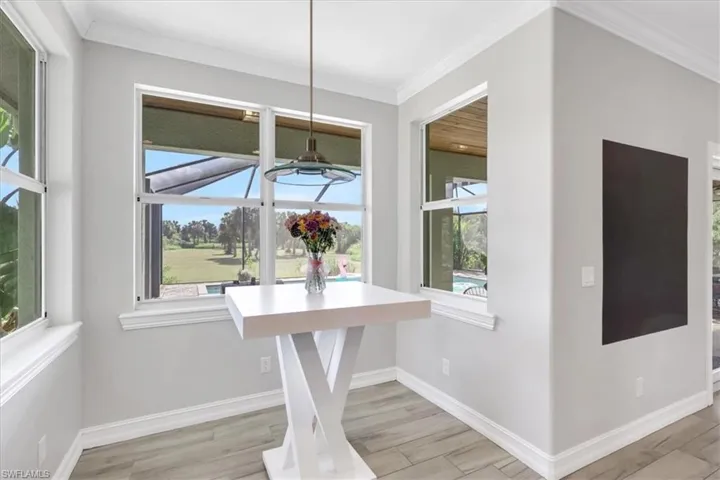Dining space featuring wood finish floors, ornamental molding, and plenty of natural light