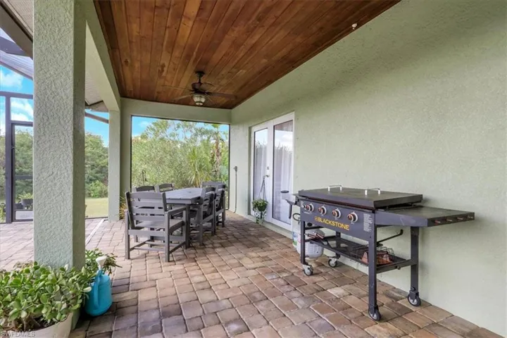 View of patio featuring outdoor dining area, ceiling fan, and area for grilling