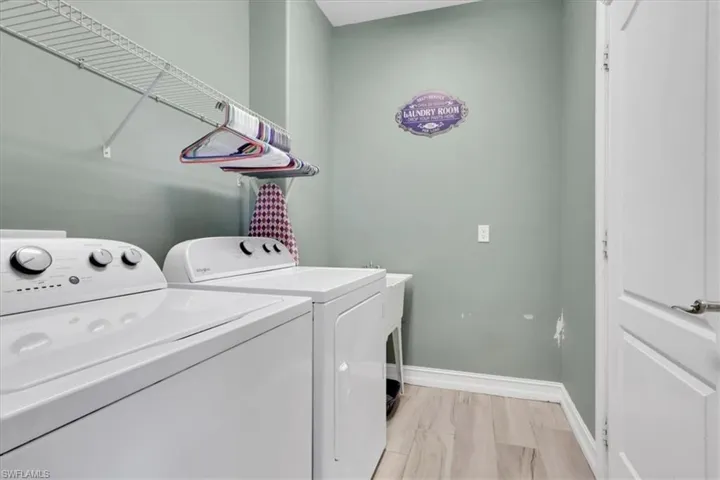 Washroom with washer and clothes dryer and baseboards