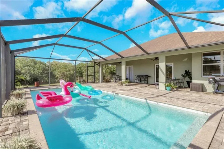 Swimming pool with a patio, a sunroom, a lanai, and a ceiling fan