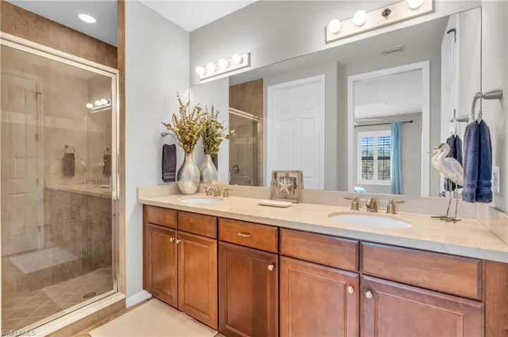 Bathroom featuring vanity, tile patterned floors, and a shower with door