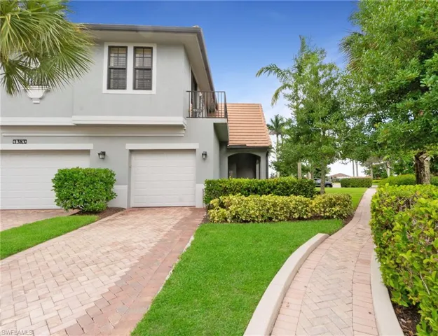 View of front of property with a garage and a front lawn