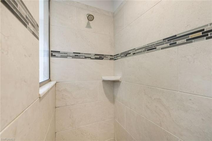An easy access stand up shower with a lovely glass tile inlay