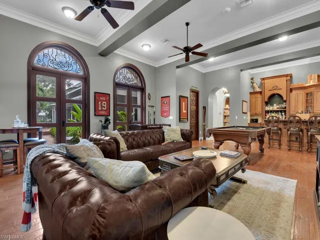 Living room with ornamental molding, light hardwood / wood-style flooring, pool table, ceiling fan, and french doors