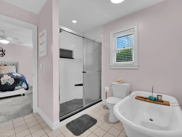 Bathroom with tile patterned flooring, toilet, sink, and walk in shower