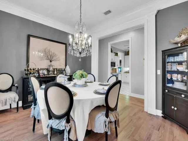Dining area with crown molding, light hardwood / wood-style flooring, and a chandelier