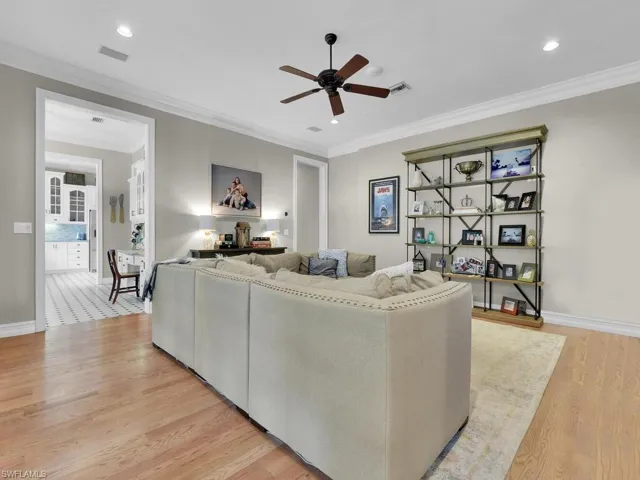 Living room with crown molding, light hardwood / wood-style flooring, and ceiling fan
