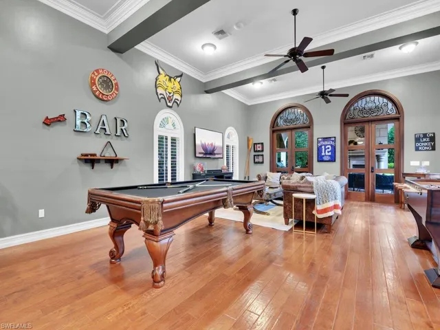 Game room with pool table, ceiling fan, ornamental molding, and light hardwood / wood-style flooring