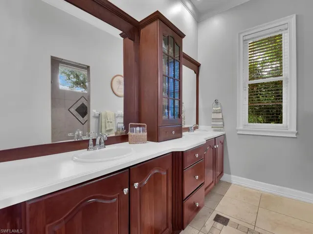 Bathroom featuring crown molding, vanity, a shower, and tile patterned flooring