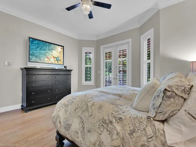 Bedroom with crown molding, french doors, light hardwood / wood-style floors, access to exterior, and ceiling fan