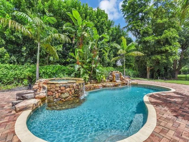 View of pool with an in ground hot tub, pool water feature, and a patio