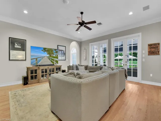 Living room featuring ceiling fan, a wealth of natural light, light hardwood / wood-style floors, and french doors