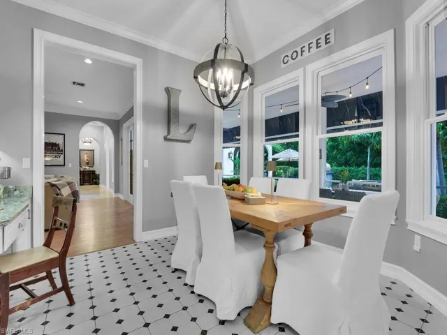 Dining space featuring ornamental molding, light hardwood / wood-style flooring, and a notable chandelier
