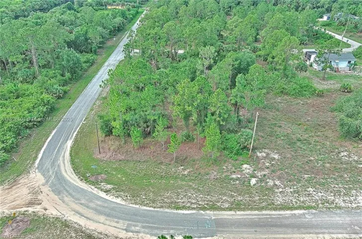 View of property location with a heavily wooded area