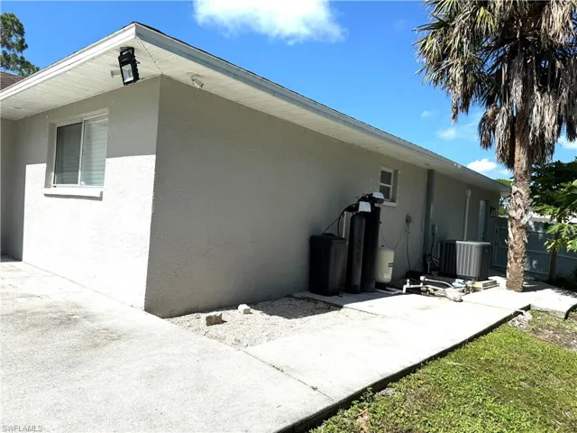 View of side of property featuring stucco siding and a patio