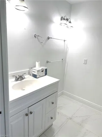 Bathroom featuring marble finish flooring and vanity