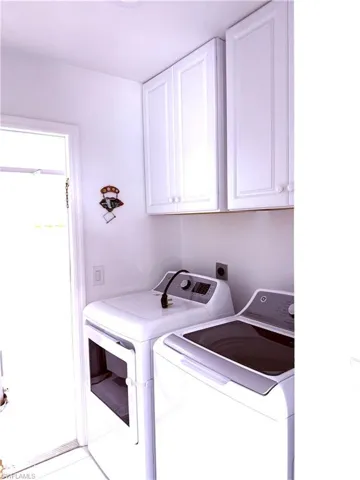 Washroom featuring washer and clothes dryer and cabinet space