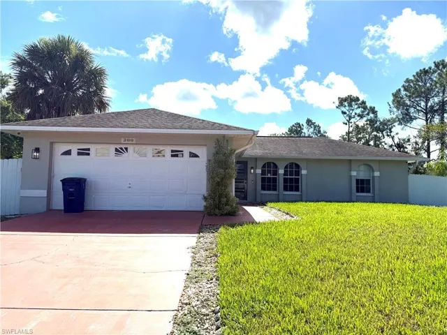 Ranch-style home featuring stucco siding, a garage, and driveway