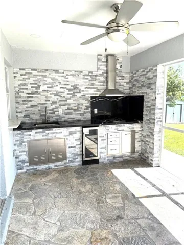 View of patio / terrace with area for grilling, wine cooler, and ceiling fan