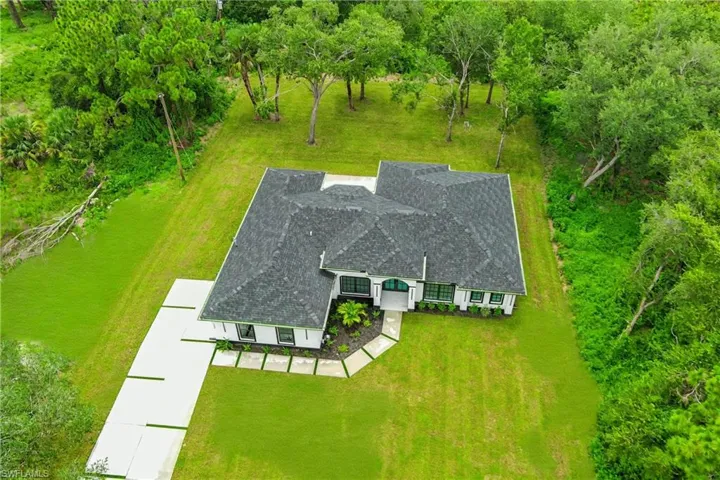 French country style house with french doors, stucco siding, a front yard, and a shingled roof