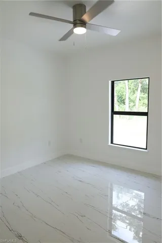 Bedroom featuring marble tiled floors and a ceiling fan