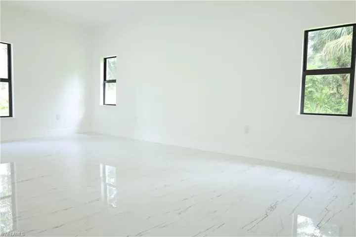 Bedroom featuring multiple windows and marble finish flooring