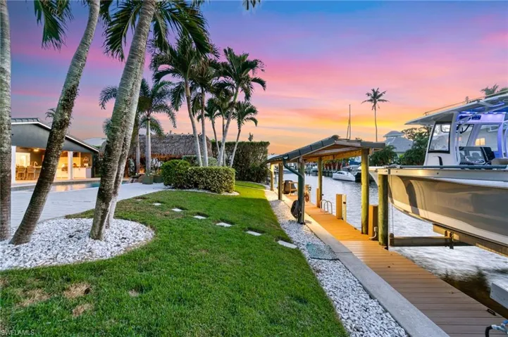 Yard at dusk featuring a dock and a water view