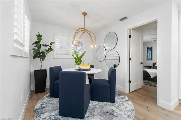 Dining room featuring plantation shutter privacy, new modern chandelier and LVP flooring throughout.