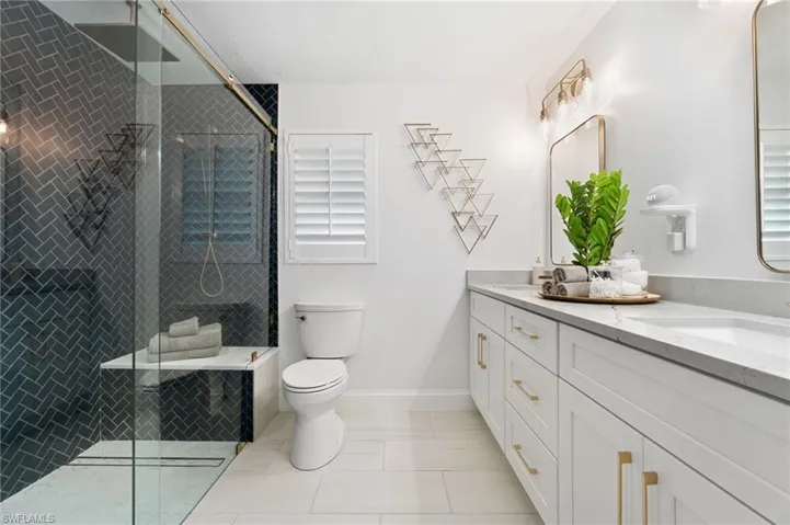 Primary Bathroom with tile patterned floors, vanity, toilet, and an enclosed shower