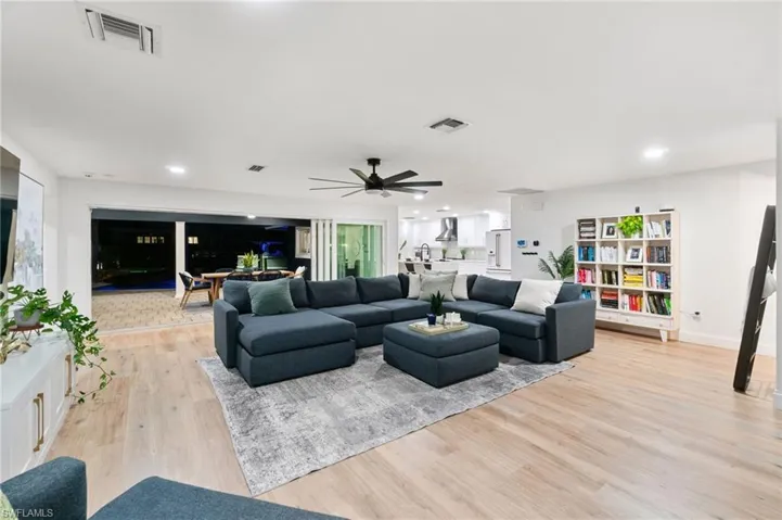 Living room with light wood-type flooring and ceiling fan