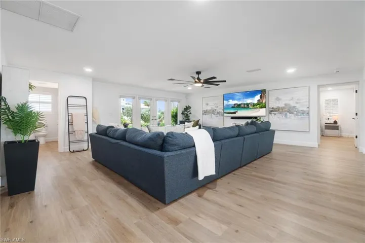 Living room with ceiling fan, french doors, and light hardwood / wood-style flooring