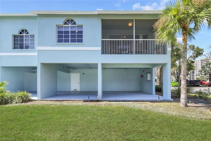 Back of property with a patio, a lawn, and a balcony