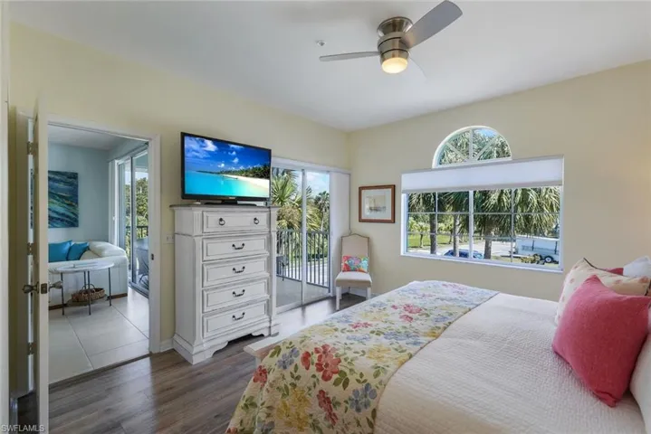 Bedroom featuring ceiling fan, access to exterior, and dark hardwood / wood-style flooring