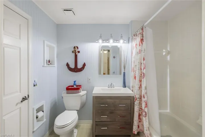Full bathroom featuring vanity, shower / bath combo with shower curtain, toilet, and tile patterned flooring