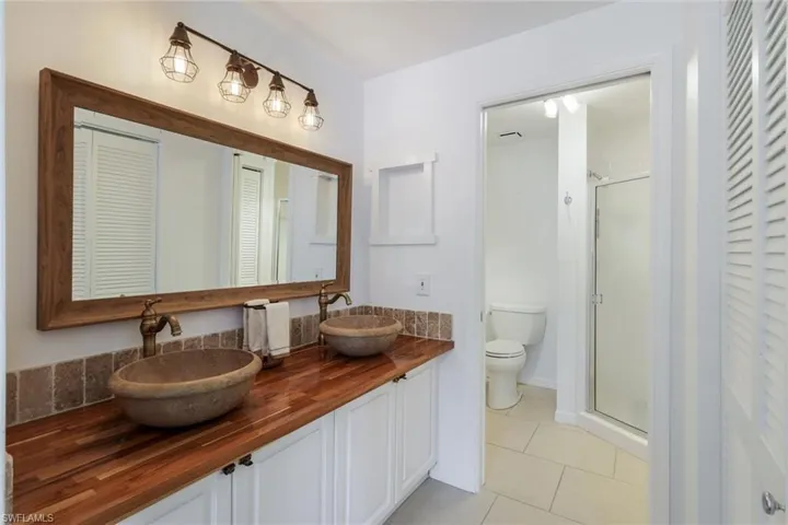 Bathroom with vanity, tile patterned flooring, toilet, and walk in shower