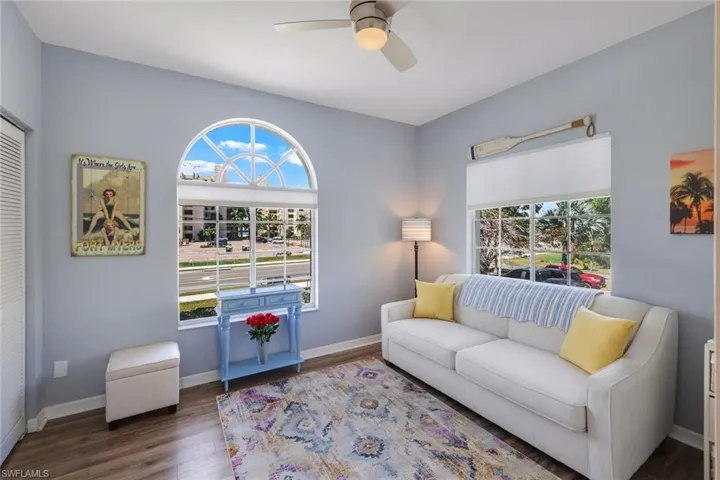 Living room featuring dark wood-type flooring and ceiling fan