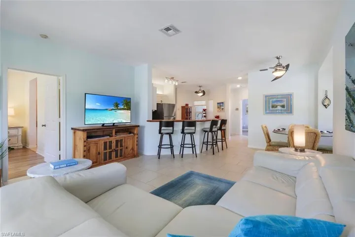 Living room with light hardwood / wood-style floors and ceiling fan