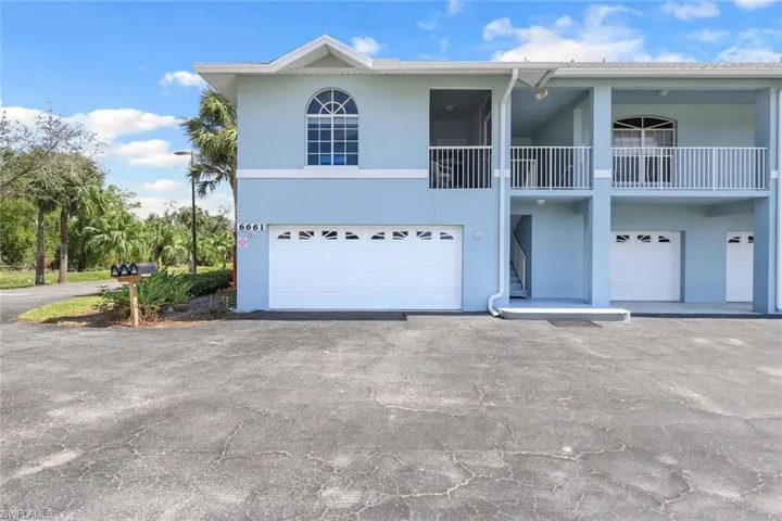 View of front of house featuring a garage and a balcony