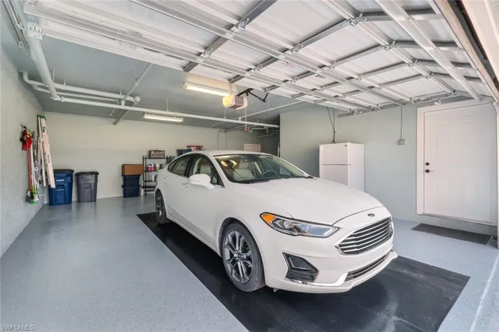 Garage with white fridge and a garage door opener
