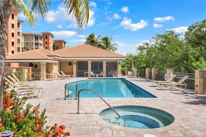 View of swimming pool featuring a patio, a community hot tub, and a sunroom